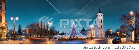 Vilnius, Lithuania. Christmas Tree On Background Bell Tower Belfry Of Vilnius Cathedral At Cathedral Square In Evening New Year Christmas Xmas Illuminations. Unesco World Heritage Site Vilnius, Lithuania. Christmas Tree On Background Bell Tower Belfry Of Vilnius Cathedral At Cathedral Square In Evening New Year Christmas Xmas Illuminations. Unesco World Heritage Site 135376755