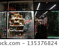 Festive christmas store window display with gnomes and trees. Festive Christmas store window display featuring decorated shelves with gnomes, snow, and holiday ornaments.  135376824