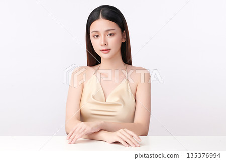 A beautiful young Asian woman with clean, fresh skin against a white background. Skincare, facial treatment, cosmetology, beauty, and spa. An elegant portrait of an Asian woman. 135376994