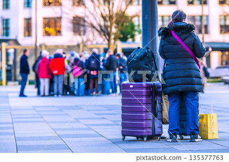 日本東京的都市景觀。行李箱…東京車站前的丸之內站廣場熙熙攘攘，擠滿了外國遊客。背景中可以看到一群外國遊客。 135377763