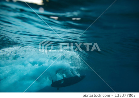 Underwater perspective of surfing through blue depths Underwater perspective of surfing through blue depths 135377802