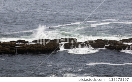 Waves crash on rocks near the Tower of Hercules in La Coruna Spain 135378197