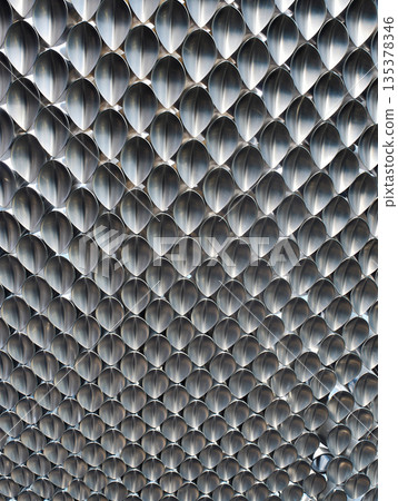 Interlocking metallic scales texture. Abstract background image. Interlocking metallic scales with an abstract, repetitive pattern create a textured surface.  135378346