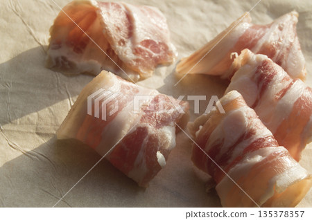 Slices of bacon are rolled into the rolls on parchment 135378357