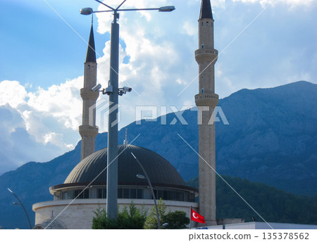 Mosque with minarets and Turkish flag with mountain backdrop horizontal 135378562