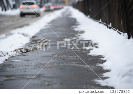 Pavement sprinkled with chemicals and technical salt against ice formation in snowy winter season. Pavement sprinkled with chemicals and technical salt against ice formation in snowy winter season. 135378895