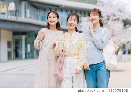 Three female college students walking on a cherry blossom campus Three female college students walking on a cherry blossom campus 135379198