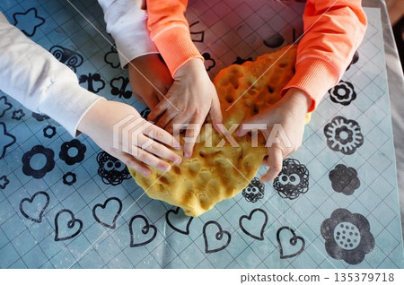 Children Kneading Dough Together in Kitchen Activity 135379718