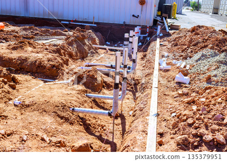 Workers are digging trench to install plumbing pipes for construction project at works zone Workers are digging trench to install plumbing pipes for construction project at works zone 135379951