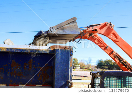 Heavy bobcat equipment transfers gravel into dump truck at construction site Heavy bobcat equipment transfers gravel into dump truck at construction site 135379970