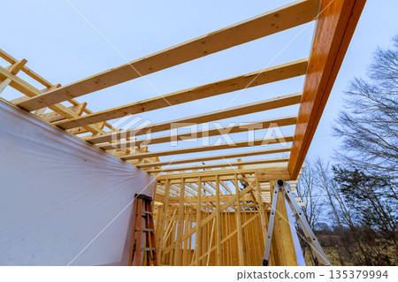 Workers are constructing wooden roof beams framework at building site Workers are constructing wooden roof beams framework at building site 135379994