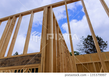 Wooden beams frames are being assembled at construction site 135379997