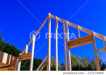 Workers are constructing wooden beams frame for building setting. Workers are constructing wooden beams frame for building setting. 135379998