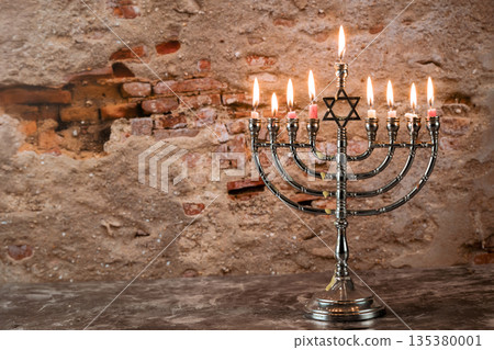 Celebrating menorah stands with lit candles Jewish holiday festive celebrating spirit of Hanukkah. Celebrating menorah stands with lit candles Jewish holiday festive celebrating spirit of Hanukkah. 135380001