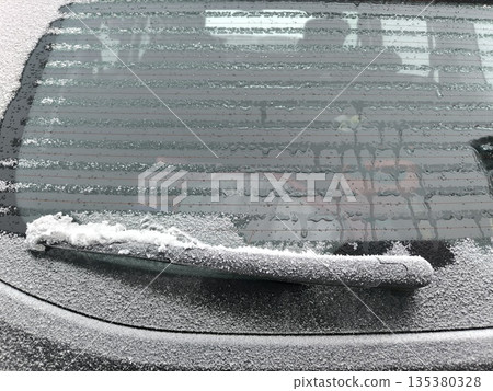 Rear window of the car is heating up and defrosting from frost Rear window of the car is heating up and defrosting from frost 135380328