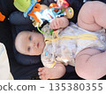 Baby Relaxing in Stroller with Colorful Toys 135380355
