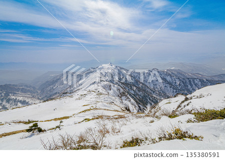 冬季山脊全景,白雪皚皚的山脊一直延伸到蔚藍的天空。 冬季山脊全景,白雪皚皚的山脊一直延伸到蔚藍的天空。 135380591