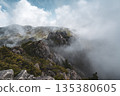 山景展現出嶙峋的山脊漂浮在雲霧繚繞之中，雲霧籠罩著山坡。 135380605