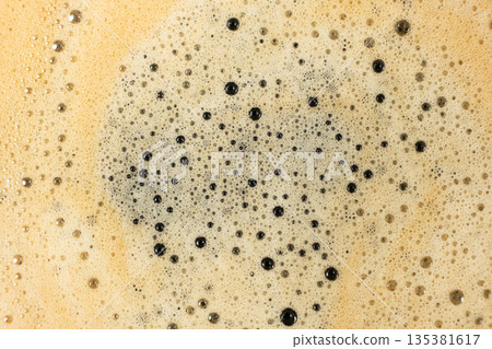 Macro texture of golden coffee foam with many small bubbles. Macro texture of golden coffee foam with many small bubbles. 135381617