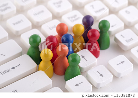 Colorful group of pawn people figures on computer keyboard 135381878