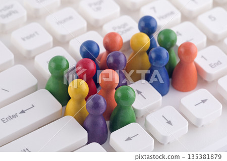 Colorful group of pawn people figures on computer keyboard 135381879