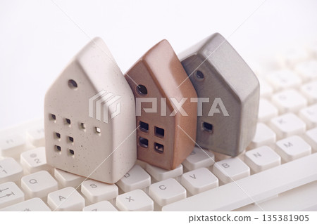Group of three different houses on white computer keyboard Group of three different houses on white computer keyboard 135381905