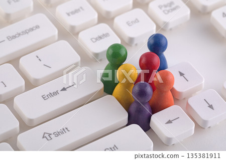 Colorful group of pawn people figures on computer keyboard 135381911