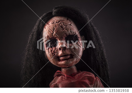 Creepy bloody doll face with long black hair in the dark Creepy bloody doll face with long black hair in the dark 135381938