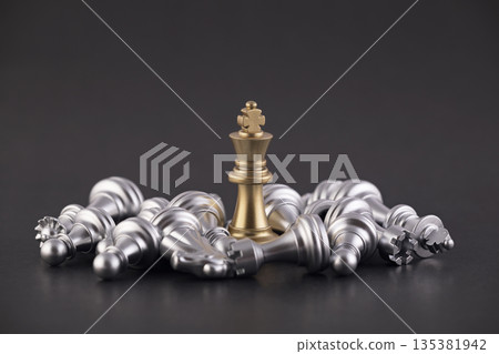 Victorious golden king with group of lying silver chess pieces 135381942