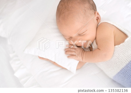 A newborn boy is sleeping sweetly, smiling in his sleep A newborn boy is sleeping sweetly, smiling in his sleep 135382136