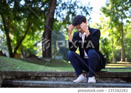 Office man stressed and sitting on outdoor steps in a green park Office man stressed and sitting on outdoor steps in a green park 135382261