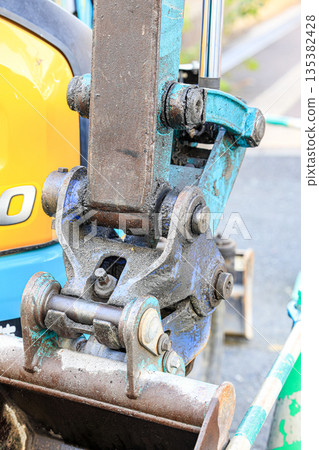 Close up detail of backhoe or excavator bucket joint part, the machine to digging the hole in construction activity. Close up detail of backhoe or excavator bucket joint part, the machine to digging the hole in construction activity. 135382428