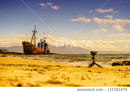 Camera on tripod and shipwreck Camera on tripod and shipwreck 135382479