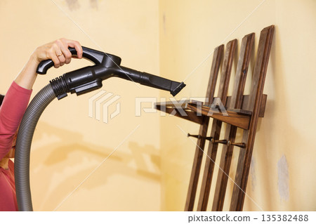 Woman cleaning dust on hanger Woman cleaning dust on hanger 135382488