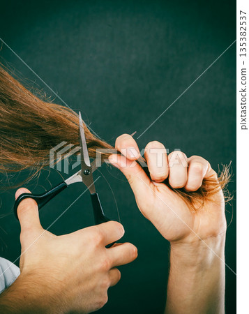 Male hands cutting long hair Male hands cutting long hair 135382537