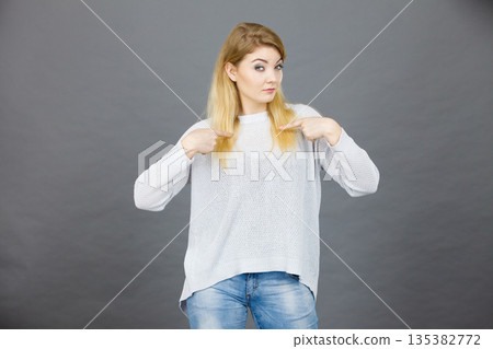 Confused woman pointing at herself Confused woman pointing at herself 135382772