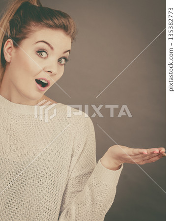 Confused young blonde woman gesturing with hands 135382773
