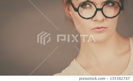 Bored focused teenage woman wearing eyeglasses 135382787