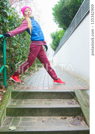 Woman wearing sportswear exercising outside during autumn Woman wearing sportswear exercising outside during autumn 135382909