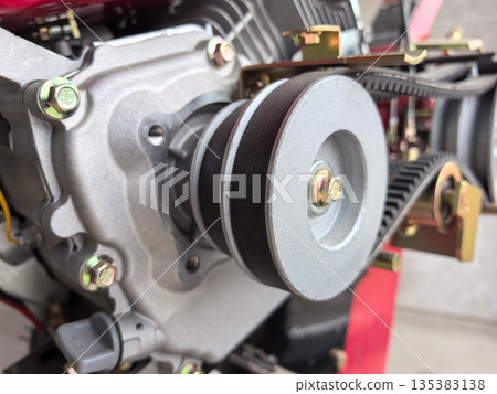 Close view of engine component showing details of pulley and belts 135383138