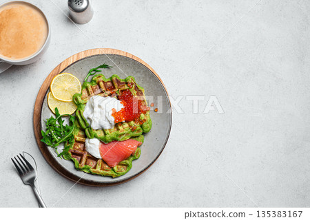 Healthy low carb breakfast with green avocado waffles, salmon, red caviar, soft cheese 135383167