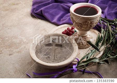 Lent ashes, communion chalice, and olive branches on stone 135383590