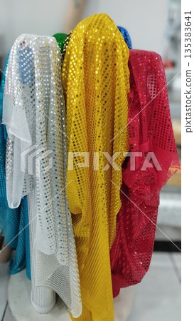 White, yellow and red fabrics with mirrored sequins White, yellow and red fabrics with mirrored sequins 135383641