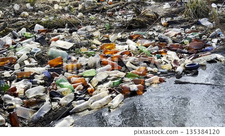 Dirty river is polluted with many plastic bottles. A lot of trash is dumped in open and freely available places at nature. Global environmental pollution problem. Concept of ecological disaster Dirty river is polluted with many plastic bottles. A lot of trash is dumped in open and freely available places at nature. Global environmental pollution problem. Concept of ecological disaster 135384120