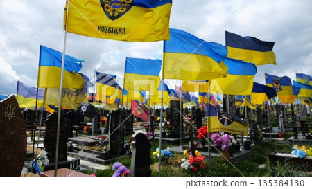 View on blue-yellow flags at countless graves of ukrainian soldiers alley of glory in Kharkiv. This site commemorates heroes and maintains the memory of wartime events in Ukraine. Slow moiton View on blue-yellow flags at countless graves of ukrainian soldiers alley of glory in Kharkiv. This site commemorates heroes and maintains the memory of wartime events in Ukraine. Slow moiton 135384130