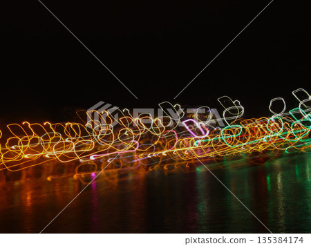 A blurry image of a body of water with lights in the water 135384174