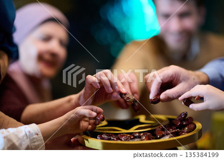 Muslim family breaking fast during Ramadan in a restaurant with Ramadan decorations Muslim family breaking fast during Ramadan in a restaurant with Ramadan decorations 135384199