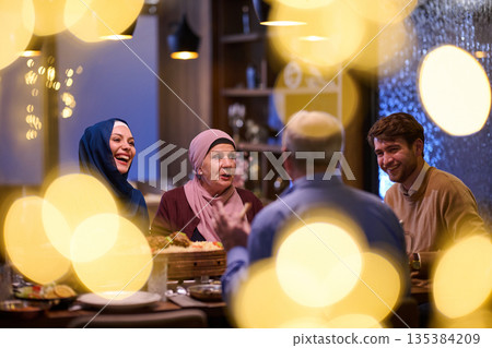 Muslim family shares iftar meal in restaurant during Ramadan with decorations and warm atmosphere Muslim family shares iftar meal in restaurant during Ramadan with decorations and warm atmosphere 135384209