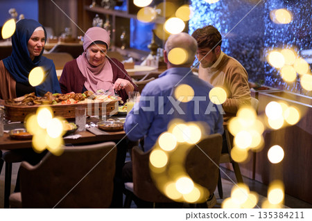 Family gathering for iftar during Ramadan in a restaurant with festive decorations Family gathering for iftar during Ramadan in a restaurant with festive decorations 135384211