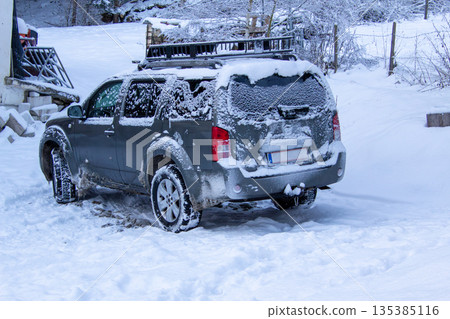 Four-wheel drive car covered with snow and ice 135385116